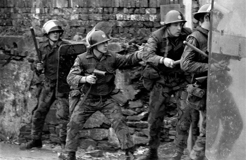 Британские солдаты с дубинками и оружием с резиновыми пулями пытаются успокоить толпу, бросающую камни. Лондондерри, 1971 год. 