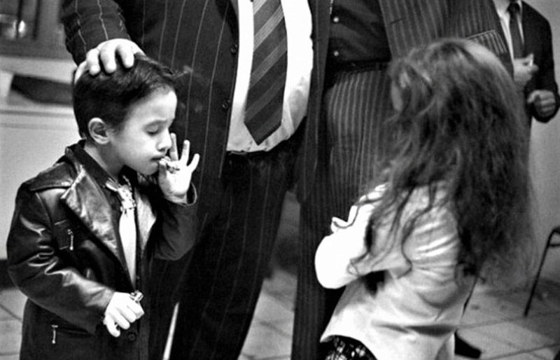 Маленький цыганский мальчик курит сигарету, что считается абсолютно нормальным в общине Сейнт Джекс, Перпиньян, южная Франция. 2006 год
