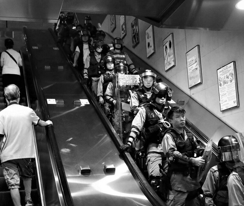 Полицейские спускаются в метро во время протестов. Специальный административный район Гонконг, КНР. 2 сентября 2019 года. 