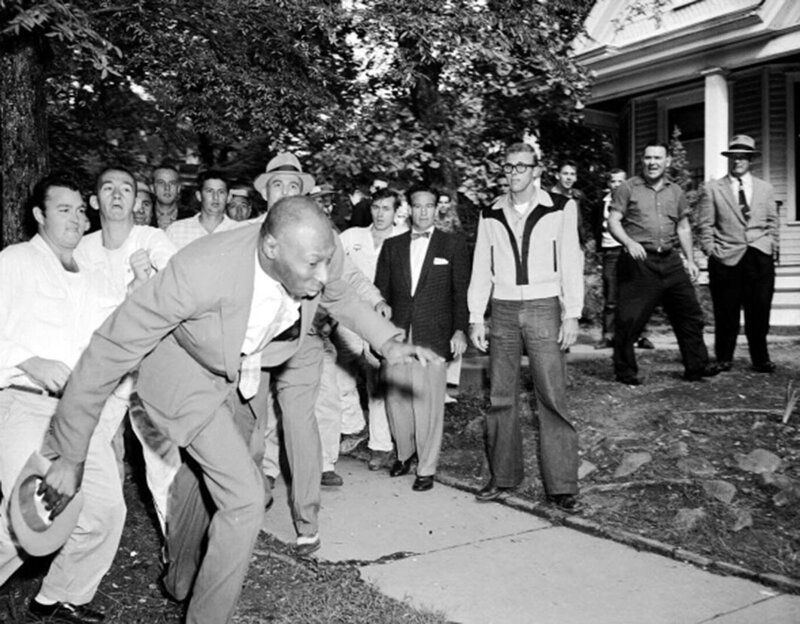 Группа расистски настроенных жителей Литл-Рока, штат Арканзас, занимается избиением и изгнанием из своего города чернокожего журналиста State Defender Алекса Уилсона , 23 сентября 1957 года. 
