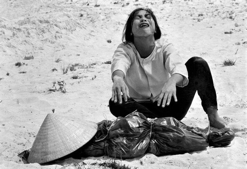 Южновьетнамская женщина плачет у тела своего мужа, найденного среди 47 тел в массовом месте захоронения недалеко от Хюэ. Вьетнамская война, Апрель 1969 года. 