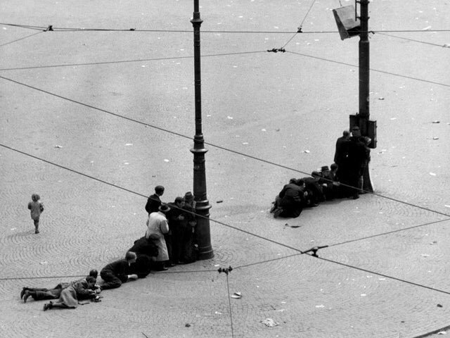 3. Жители Амстердама прячутся за фонарными столбами на площади Дам во время обстрела немецкими войсками, 1945