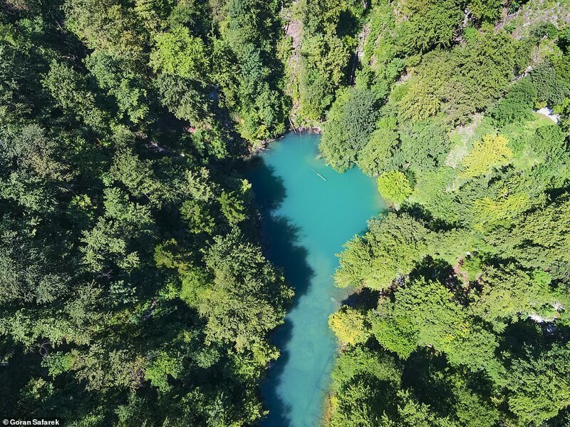Яркие голубые воды истока реки Купа в национальном парке Рисняк в северной Хорватии. Он окружен скалами, покрытыми ярким зеленым лесом