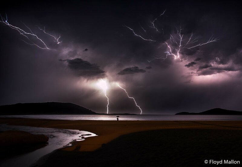 Победитель в категории «Юниор». «В темноте». Человек с зонтом у самой воды, залив Фингал, Новый Южный Уэльс. Автор фото: Флойд Маллон.