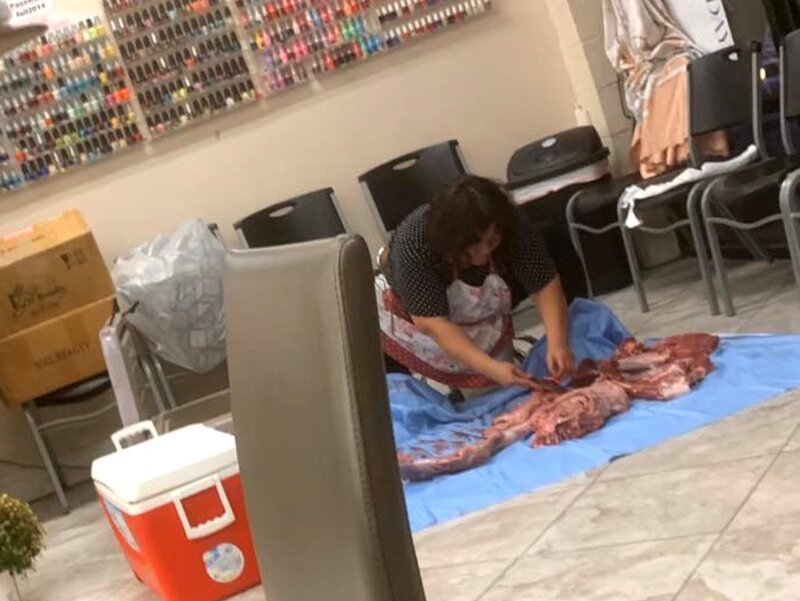 Женщина брала голыми руками мясо и отрезала от него куски, складывая их в пакетик. 