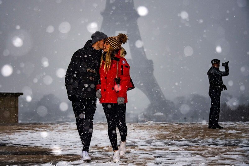 14. Пара на фоне заснеженной Эйфелевой башни в Париже