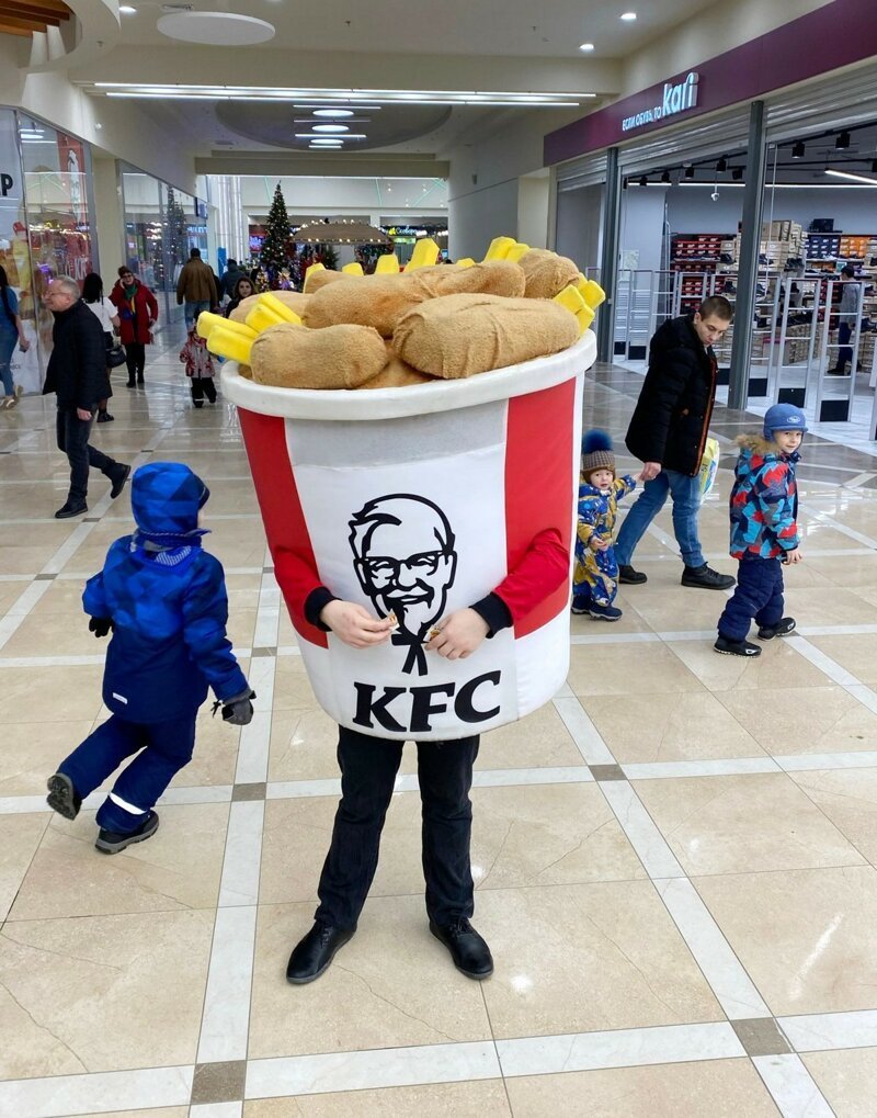 Реклама курятины с картофелем фри в одном из гигантских торговых центров Мурманска, куда местные жители едут за покупками при ярком освещении.