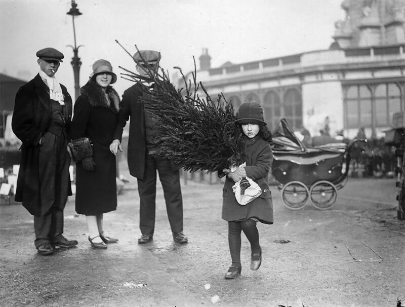 Девочка несет домой рождественскую ель с рынка на Каледониан-Роуд, Лондон, 1929 год 