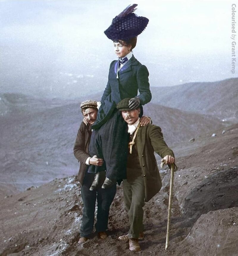 Два горных гида несут туристку, осматривающую места вблизи вулкана Везувий, которые были покрыты лавой после извержения 5 апреля 1906 г. 