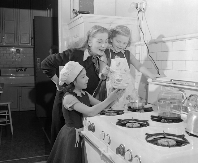 Джоанна Фонтейн готовит обед с дочками, 1955