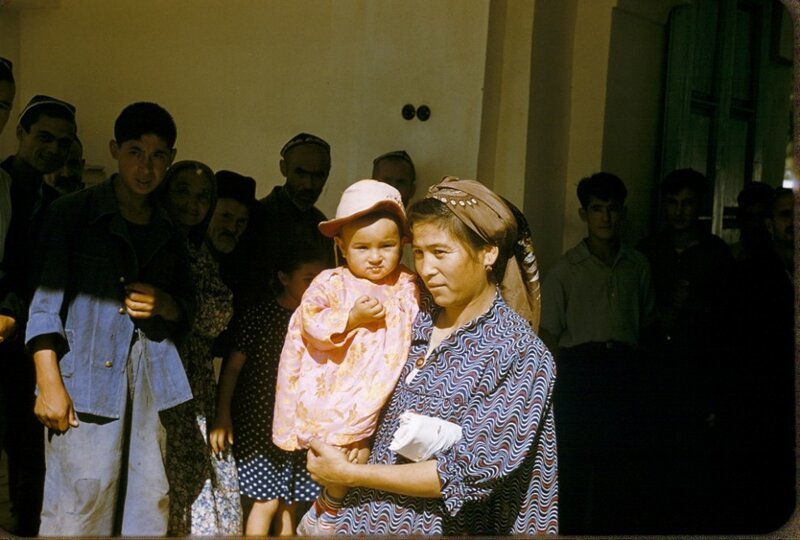 Женщина с ребенком перед мечетью.