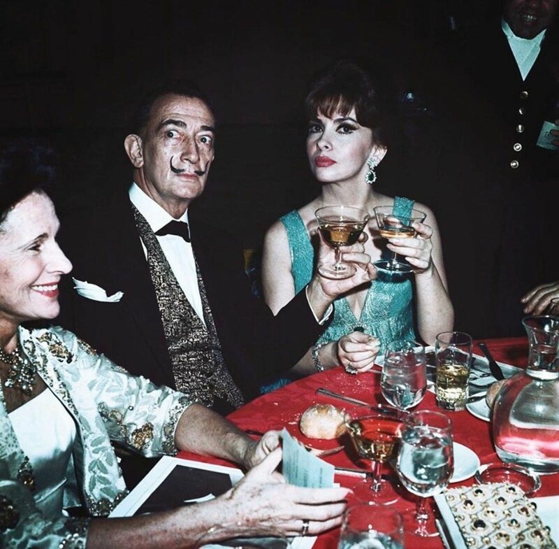 Гала и Сальвадор Дали пьют шампанское с Джиной Лоллобриджидой на ужине по случаю премьеры фильма «Звуки музыки», 1965-й год. 