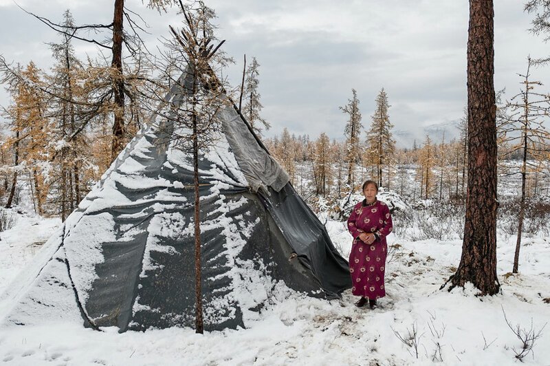 Пурев — женщина-оленевод и глава семьи — стоит рядом с традиционным семейным жилищем цаатанов под названием урц (чум), Алтайские горы, Монголия.