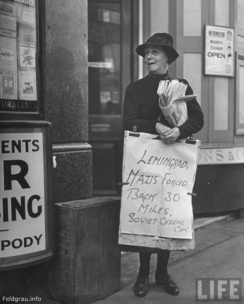 Дама, продающая газеты в Лондоне, держит в руках плакат с главной новостью: "Ленинград. Немцы отброшены на 30 миль". 