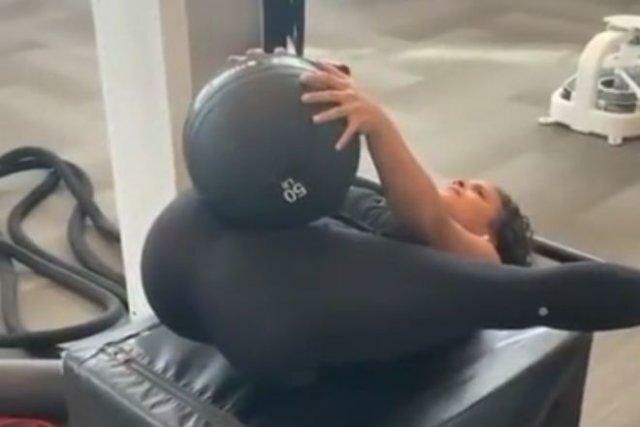 Девушка выполняет в спортзале интересное упражнение