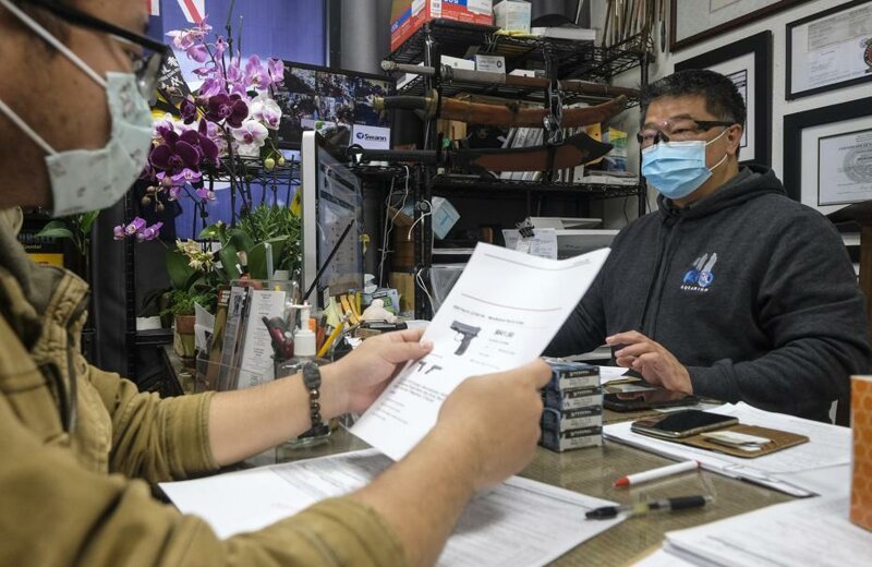 Владелец оружейного магазина Дэвид Лиу принимает заказ от клиента в Аркадии, штат Калифорния