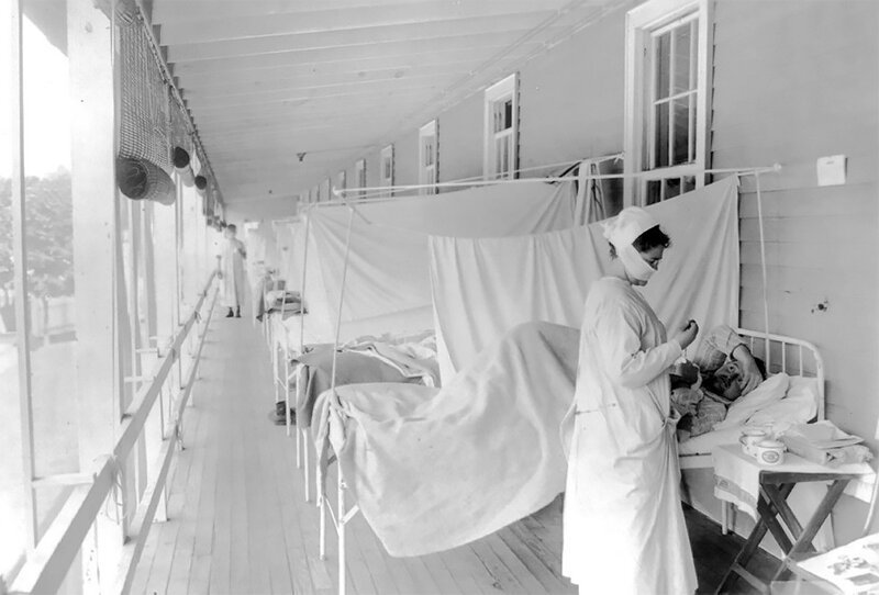 Медсестра измеряет пульс пациента в карантинном отделении больницы Уолтера Рида в Вашингтоне, Колумбия, ноябрь 1918 
