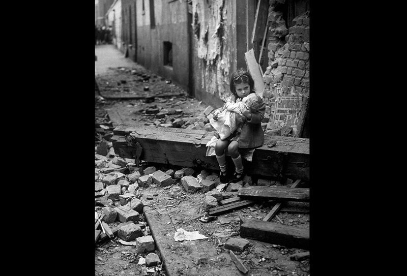 Маленькая девочка на пороге своего дома в Лондоне, который был разрушен бомбардировкой в 1940 году.