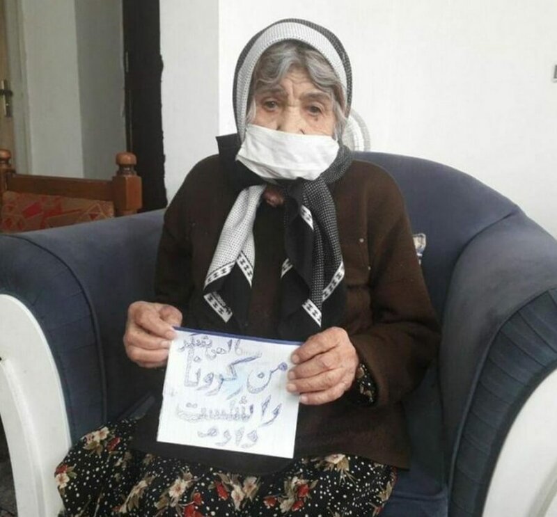  Этой женщине из Ирана 103 года и ей позволили вернуться домой, а на плакате написано "Я победила коронавирус"