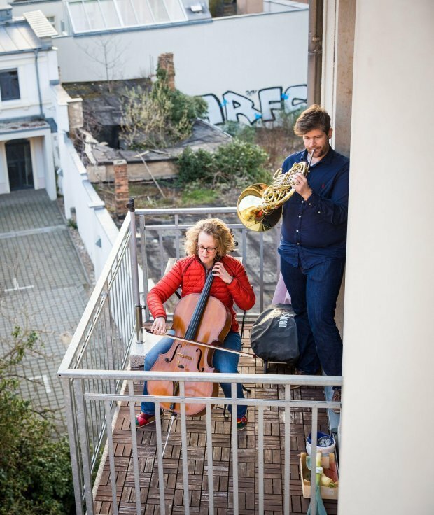 Музыканты Каролина Штробл и Золтан Максаи исполняют "Оду к радости" на своем балконе в Дрездене, Германия