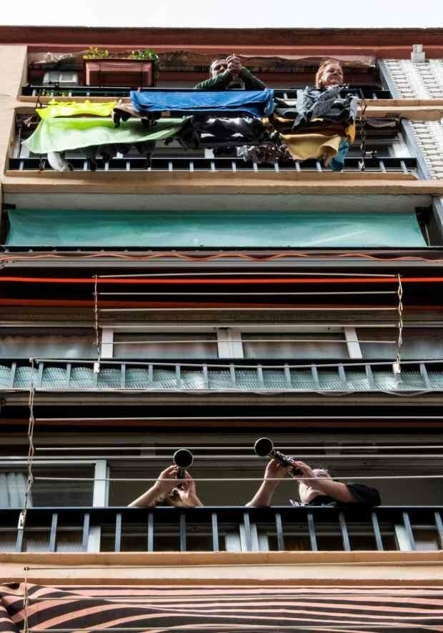 Люди играют на кларнете на своем балконе во время домашнего карантина в Валенсии, Испания