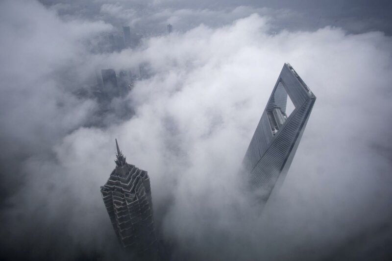 Шанхайский всемирный финансовый центр (справа) и башня Цзинь Мао во время сильного дождя в Шанхае, Китай.