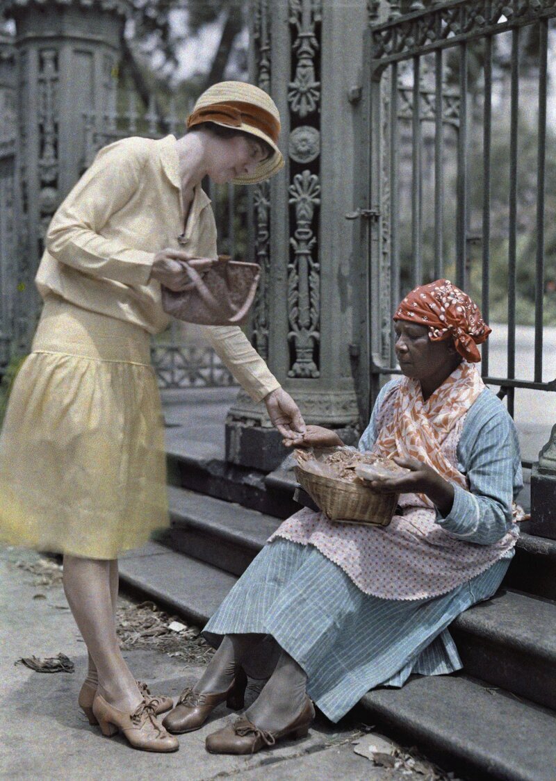 1929. Новый Орлеан, Луизиана – женщина, сидящая на каменных ступенях в Французском квартале, продает пралине. Автор фото: Эдвин Л. Вишерд
