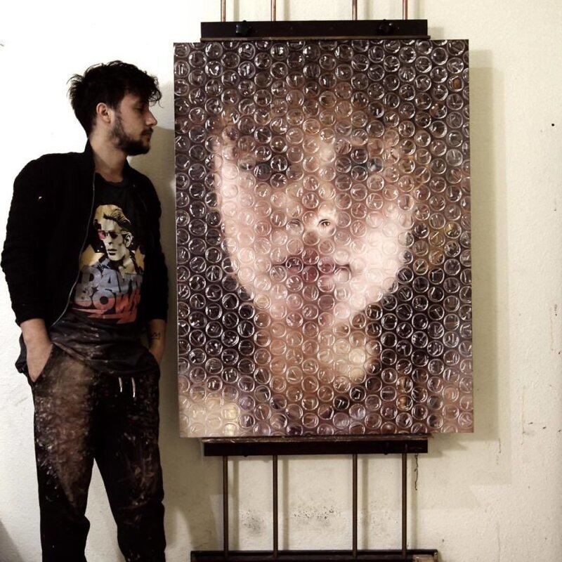 Художник рисует портреты, которые как-будто бы завёрнуты в пузырчатую плёнку 