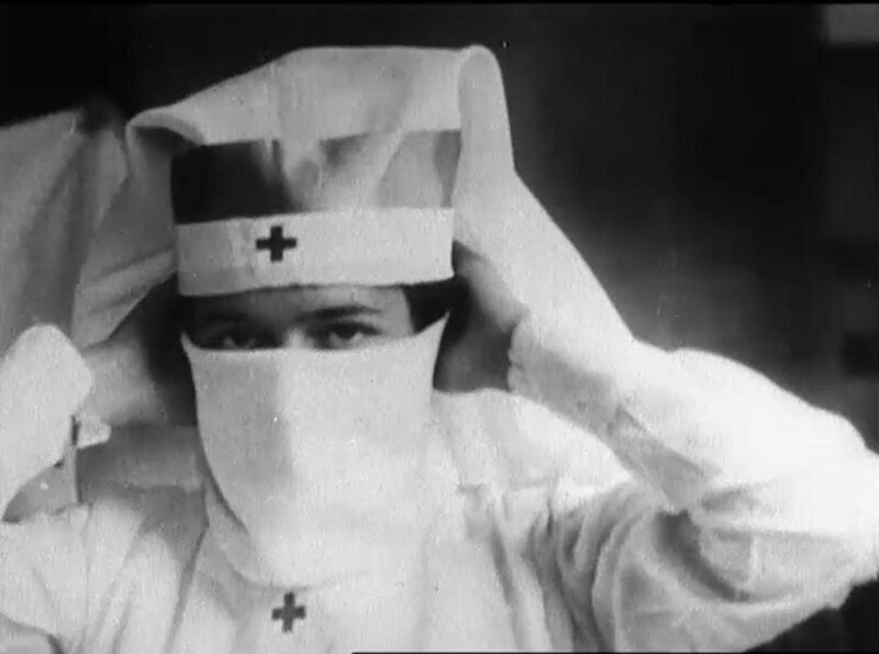 Медсестра Красного Креста демонстрирует, как надевать маску во время пандемии испанского гриппа, Бостон, 1918 год.