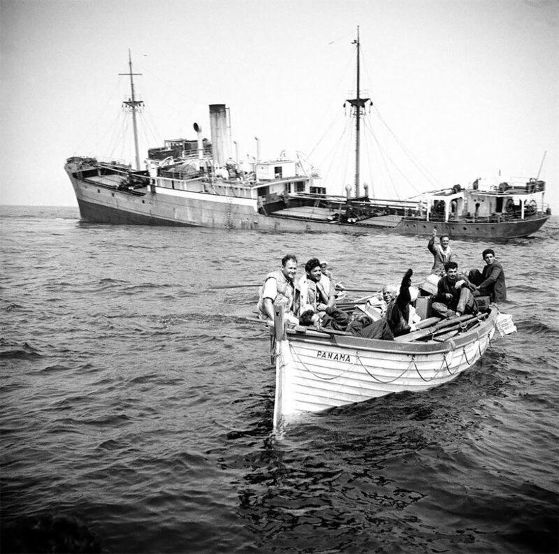 Панамское судно Punta идет ко дну, а его экипаж спасается в шлюпке, 1955 год.