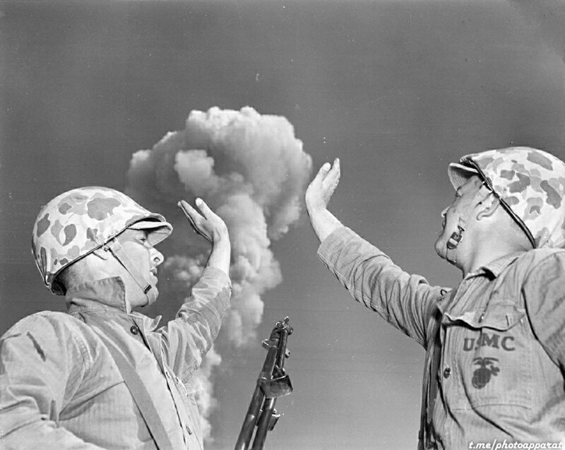 Американские солдаты фотографируются, делая вид, что трогают грибовидное облако, созданное ядерным взрывом в пустыне штата Невада, США, 1952 год.