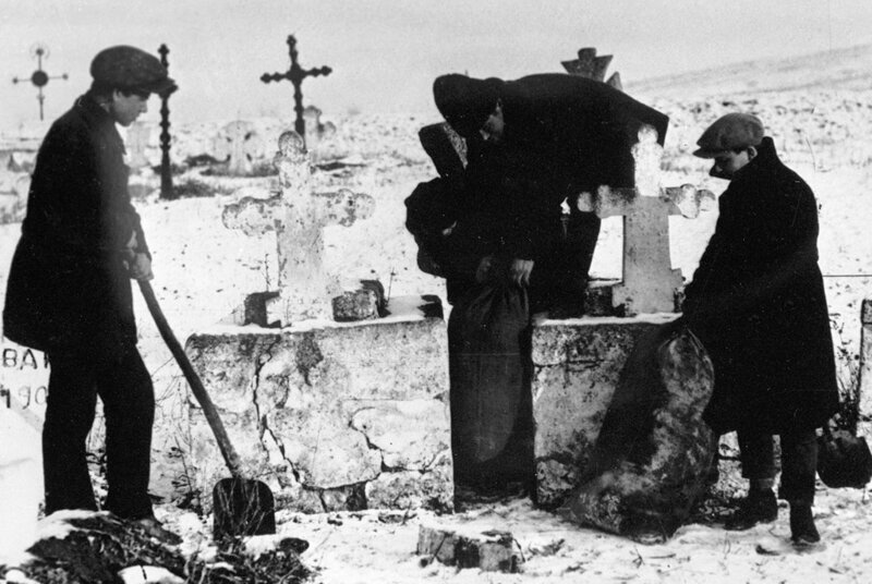 Комсомольцы извлекают зерно, спрятанное кулаками на кладбище. Украина. 1930 год.