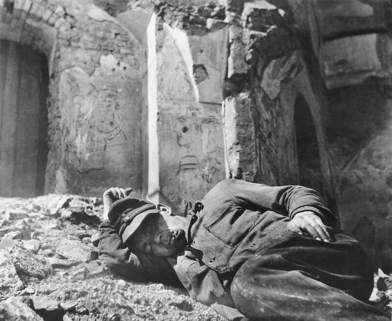 Вернувшийся домой бывший немецкий военнопленный спит у разрушенного дома, в котором была его квартира. Мюнхен. Американская зона оккупации Германии. 1946 год.
