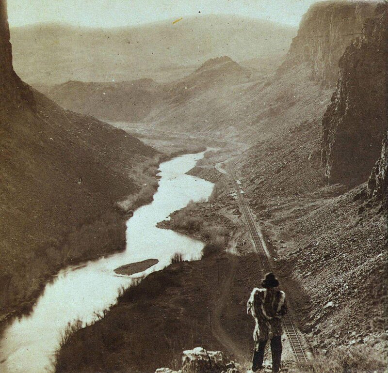 Коренной житель Америки смотрит вниз на только что построенный участок трансконтинентальной железной дороги, Невада, примерно 1868 год.