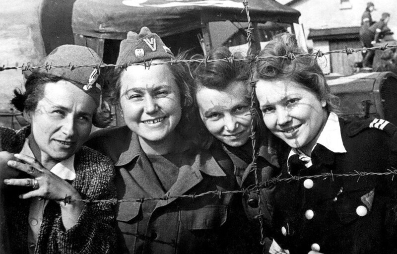 Четыре женщины, захваченные в плен немцами в ходе Варшавского восстания, сфотографированы через колючую проволоку в лагере Шталаг VI-C после их освобождения. Третий Рейх. Апрель 1945 года.