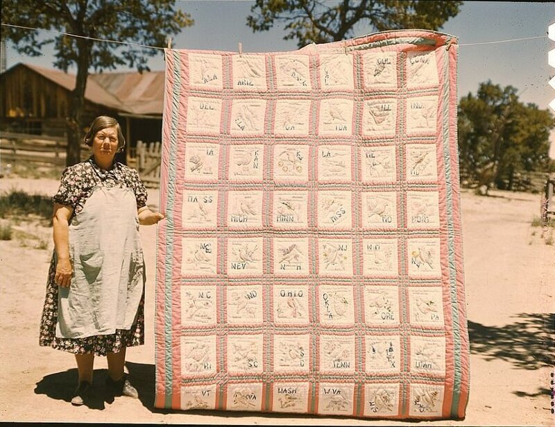 Женщина показывает одеяло, на котором вытканы все птицы — символы штатов.