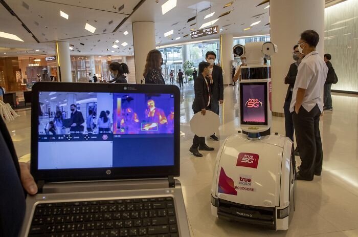 Робот в торговом центре измеряет температуру прохожих
