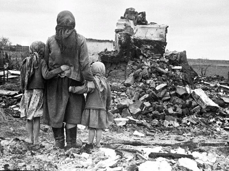 Женщина с двумя девочками смотрит на развалины родного дома. СССР, 01.09.1943