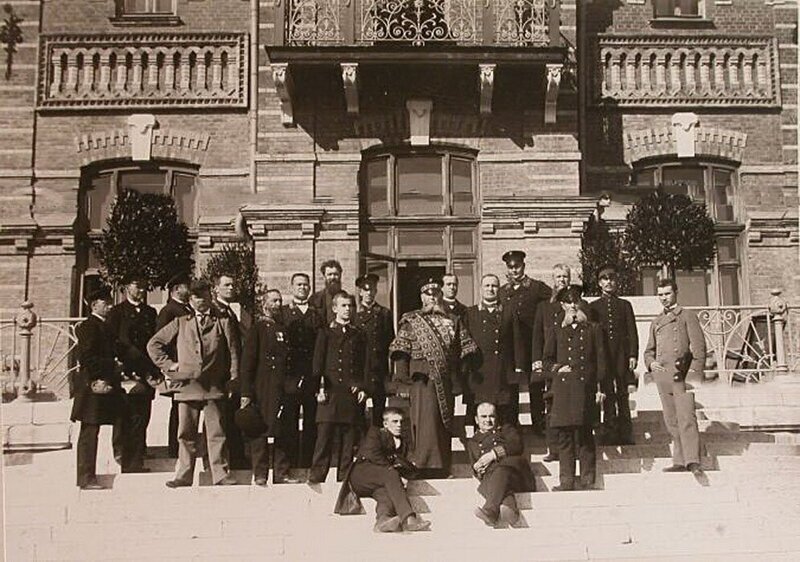 Швейцар (в центре) и другие штатные служащие Беловежского дворца у здания дворца