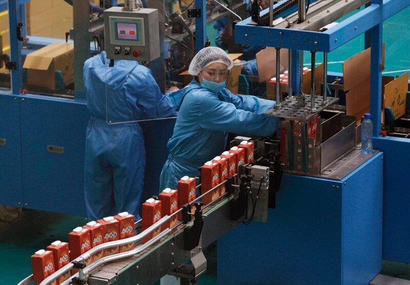 Работницы на производственной линии фруктового сока на заводе Daedonggang Fruit Farm на окраине Пхеньяна.