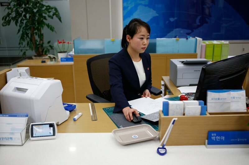 Северокорейская сотрудница работает в банке в промышленной зоне Кэсона.