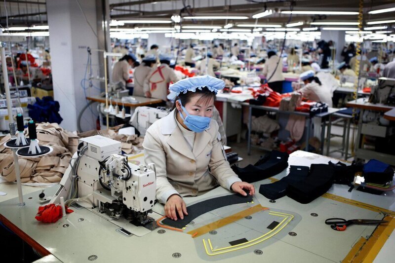 Женщина работает на заводе южнокорейской компании в промышленной зоне Кэсона.