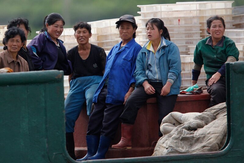 Работницы на перерыве на рыбацкой лодке в порту Раджин.