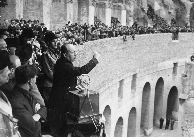 Окруженный членами партии Бенито Муссолини в 1929 году выступил с речью в римском Колизее