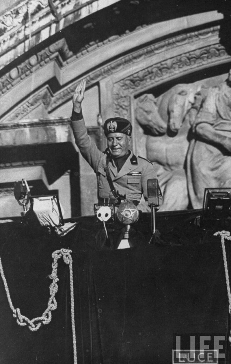 Бенито Муссолини приветствует собравшуюся огромную толпу народа внизу