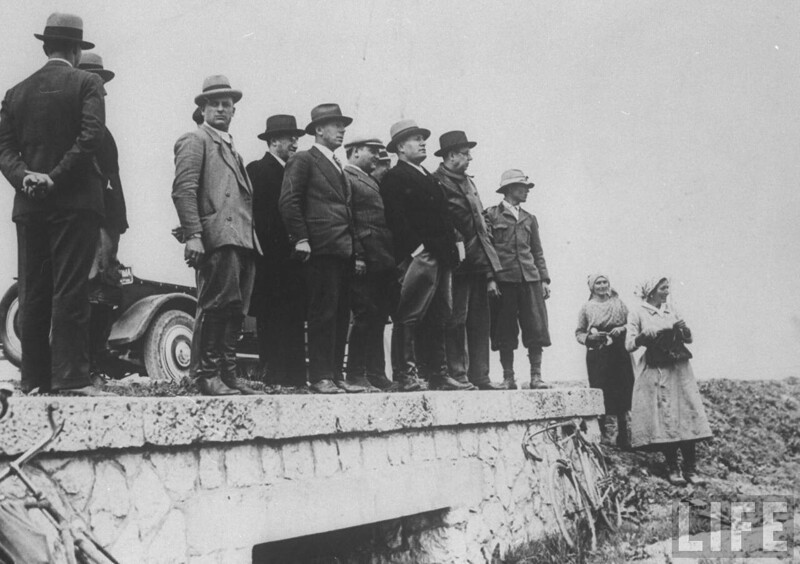 Бенито Муссолини стоит на каменном мосту, осматривая мелиорированные Понтийские болота. 1930