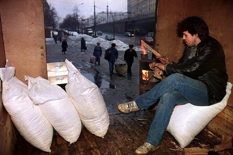 Продавец в задней части грузовика рядом с дровяной печью продает мешки с сахаром в Москве. Они продаются за 26 000 рублей (20 долларов США) за мешок. 17 декабря 1993 года.