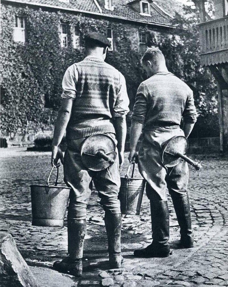 Студенты Сельскохозинститута со стульями для дойки. Германия, Нойдек, 1934 год.