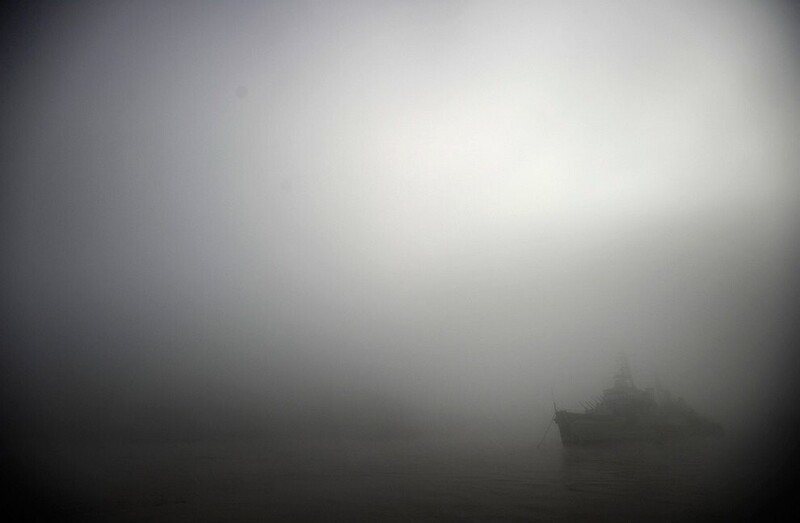 В тумане виднеется бывший британский легкий крейсер HMS Belfast, который находится постоянно на стоянке в центре Лондона на реке Темзе, возле Тауэрского моста. (Фото Dylan Martinez | Reuters):