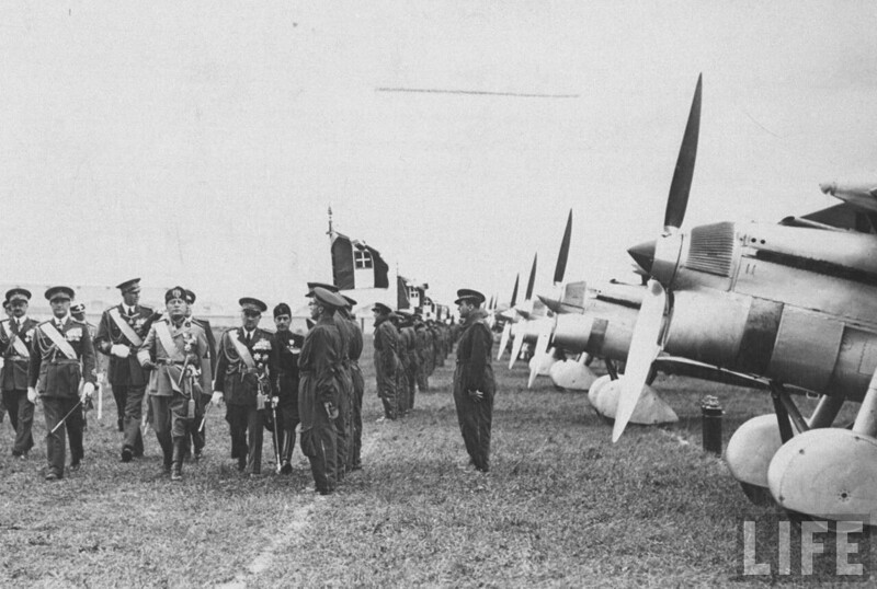 Бенито Муссолини с офицерами проходит мимо строя летчиков во время авиационного шоу.1940